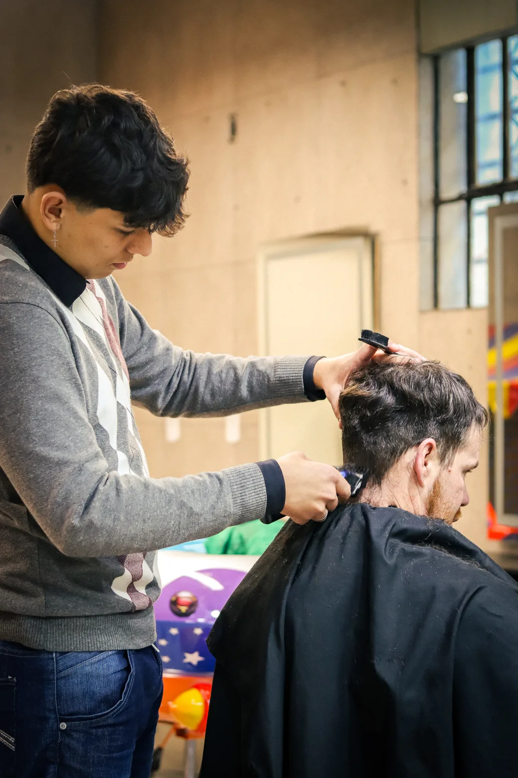 Barbeiro finalizando corte de cabelo na OS BEAUTY