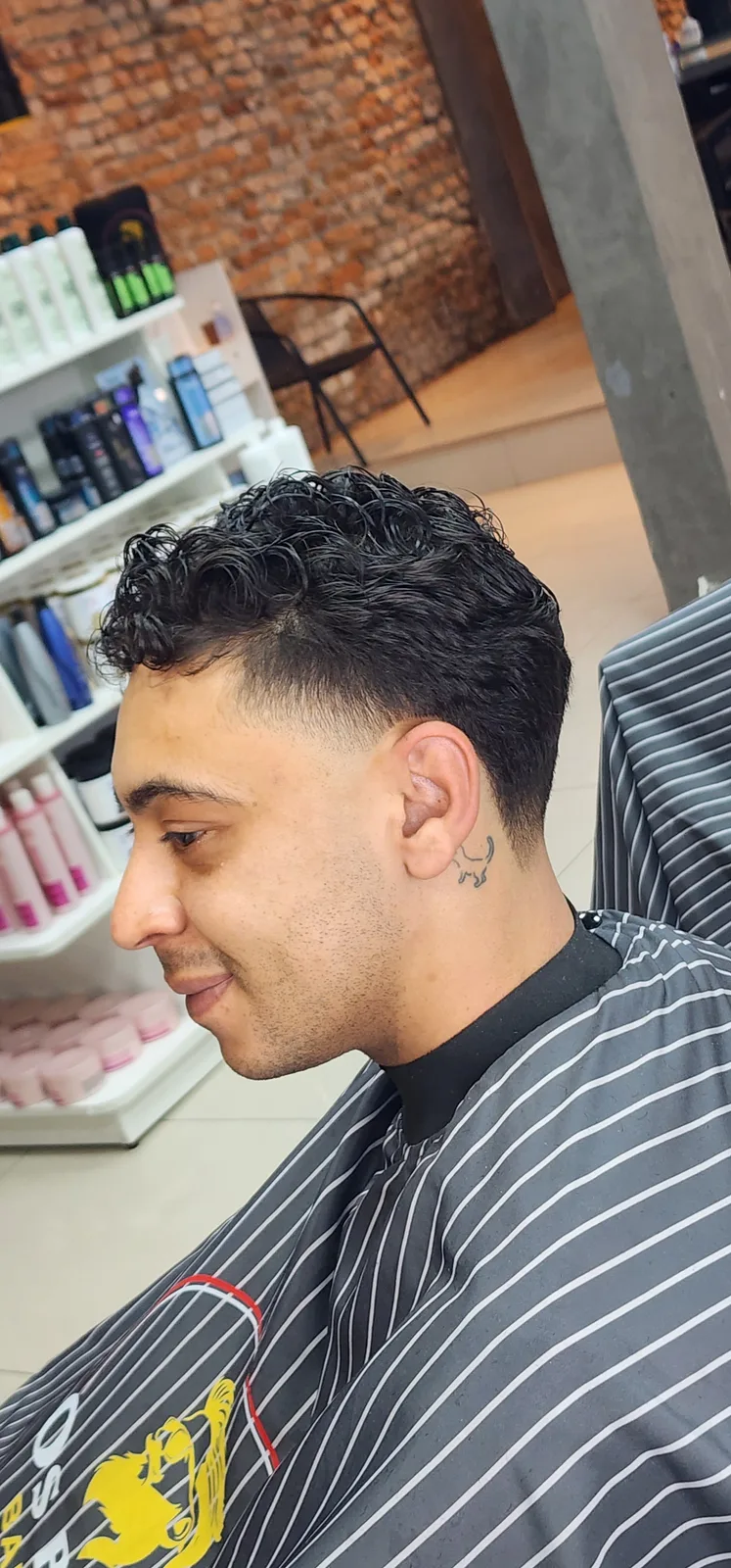 Cliente com corte masculino na cadeira da barbearia
